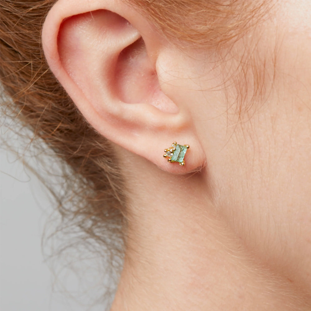Detail view of model wearing Raw Emerald and Diamond Encrusted Stud Earring by Ruth Tomlinson in right ear.