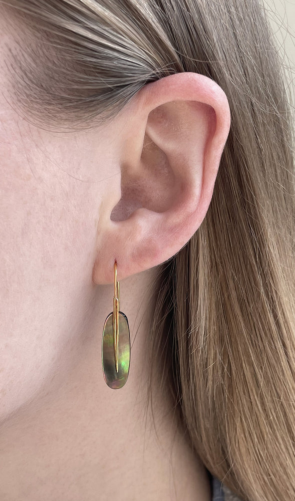 Close-up view of model wearing Small Feather Earring with Black Mother of Pearl by Rachel Atherley on left ear
