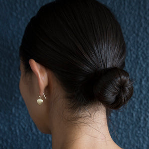 Rear view of model wearing Ravan Drop Earrings by Dan-Yell on left ear.