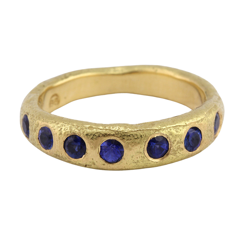 Angled view of Narrow Molten Band in 18k yellow gold with blue ceylon sapphires by Betsy Barron