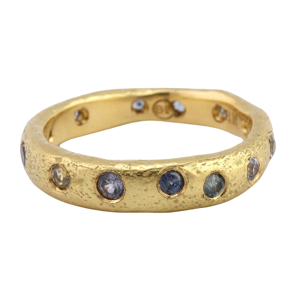 Angled view of Narrow Molten Band in 18k yellow gold with Montana sapphires by Betsy Barron