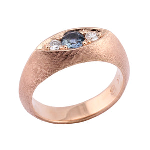 Angled view of 14k rose gold guardian eye ring with 4.5mm Montana sapphire center stone and two 2.5mm white diamond side stones by Betsy BArron.