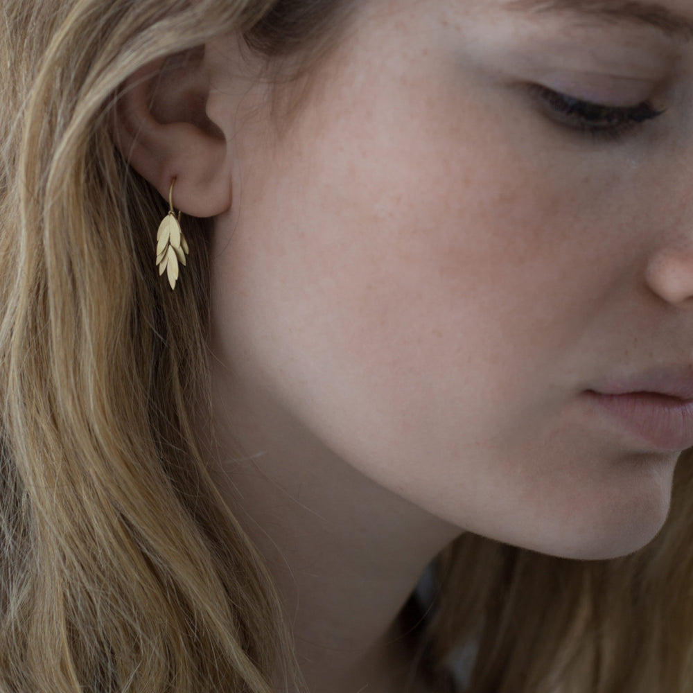 Detail view of model wearing Small Golden Leaf Earrings by Sia Taylor