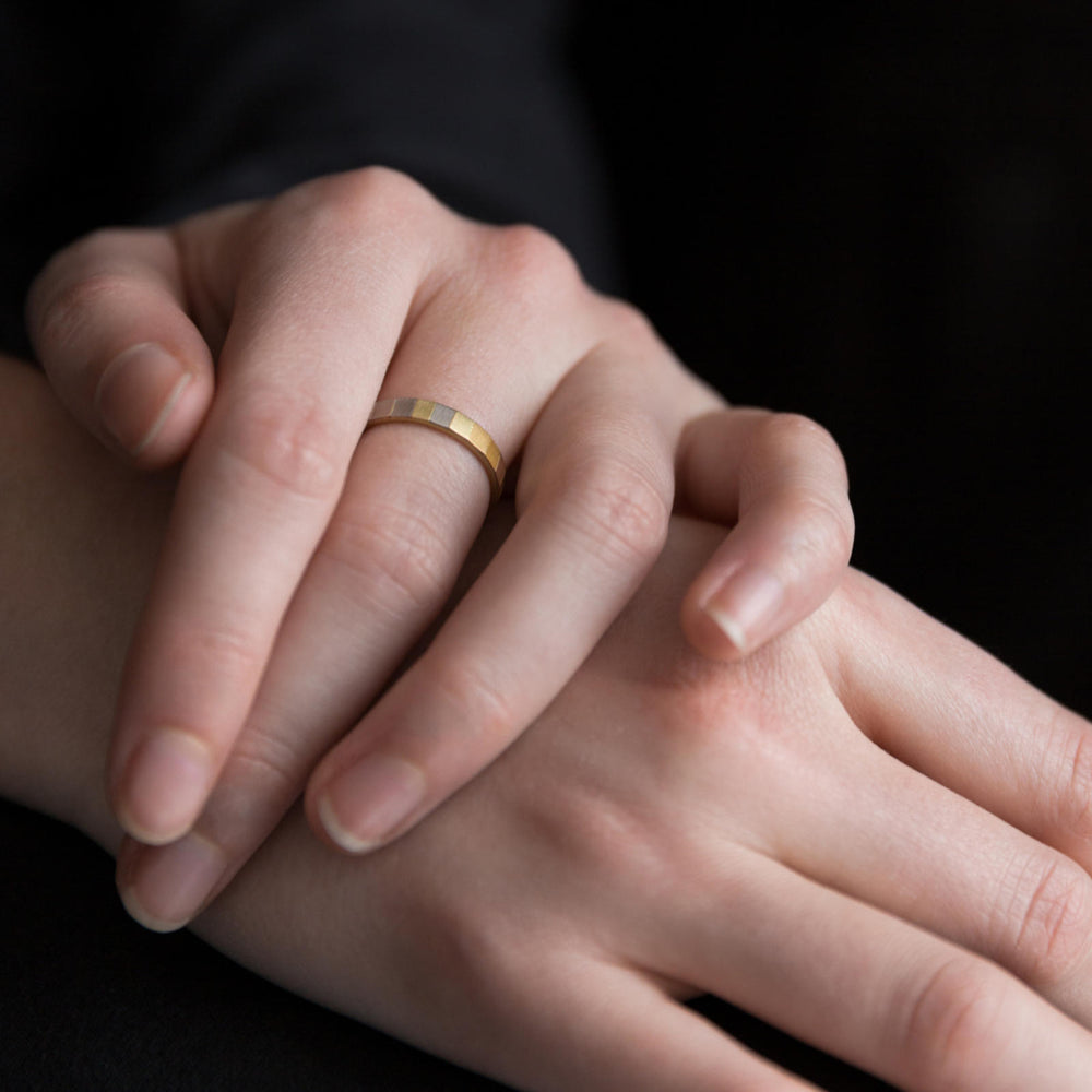 Detail view of model wearing Wide Rainbow Faceted Band by Sia Taylor on left hand