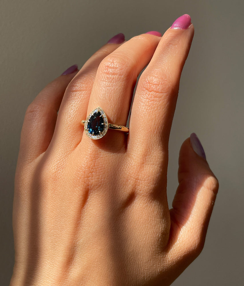 Detail of model wearing Hidden Gate Blue Green Sapphire and Diamond Ring by The North Way Studio on left hand.