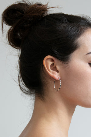 Detail view of model wearing Ravi Hoop Earrings by 5 Octobre