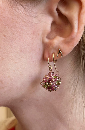 Detail view of model wearing Allium Spring Earrings by Stephen Dove on left ear.