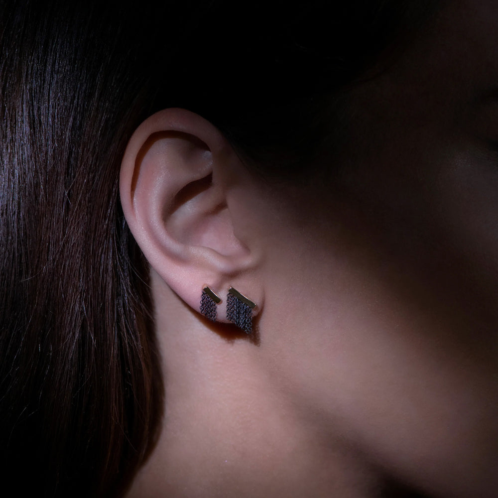Detail view of model wearing fringe stud earrings by Andrea Blais on right ear.