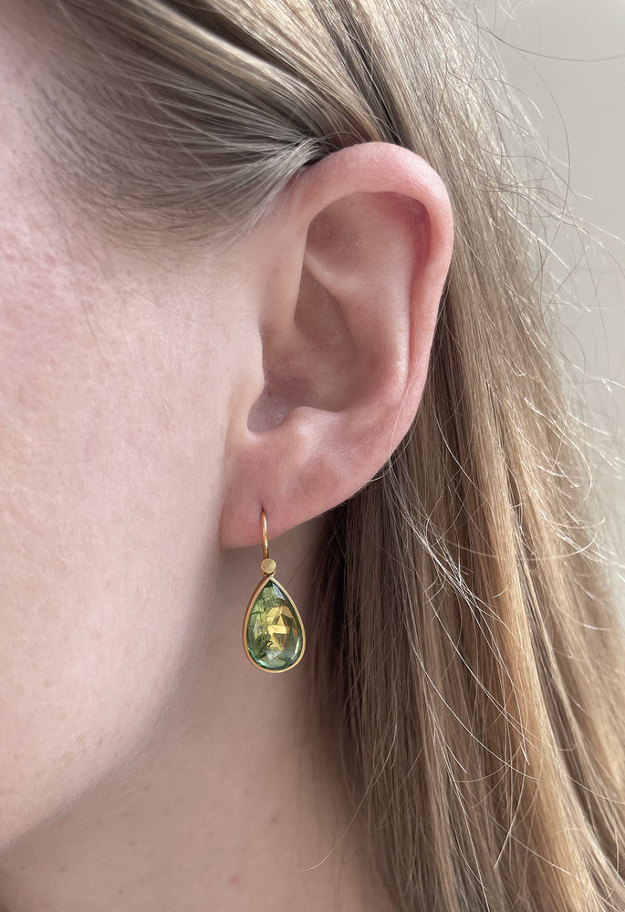 Close-up view of model wearing Pale Green Tourmaline Drop earring by Lola Brooks on left ear