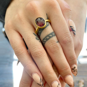 Closeup view of model wearing Oval Orange Natural Sapphire Ring by Lola Brooks on right middle finger.