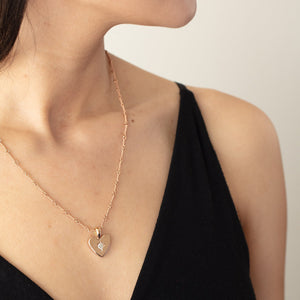 Detail view of model wearing small classic heart pendant with white diamond by Betsy Barron Jewellery.